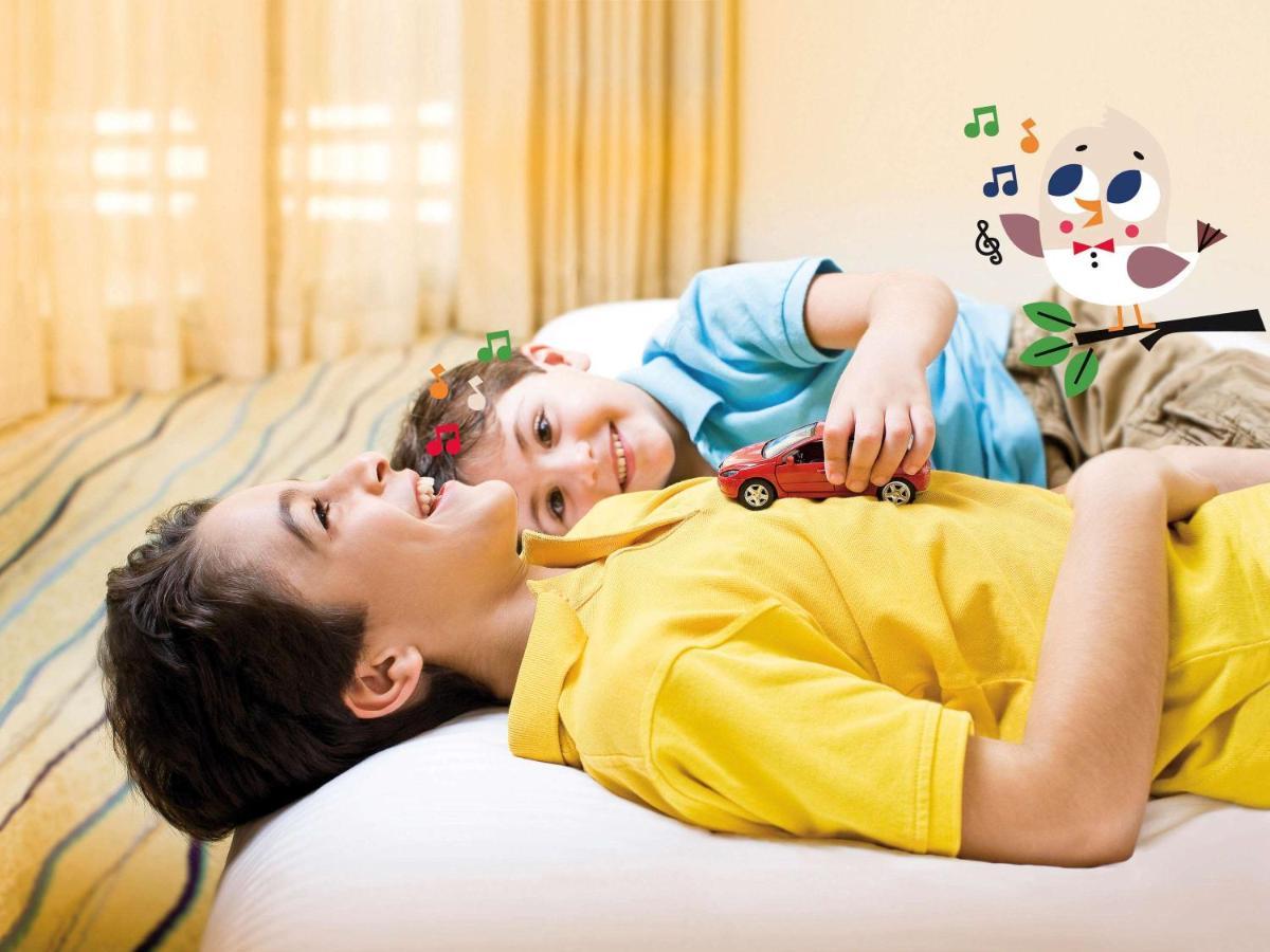 Movenpick Jumeirah Village Triangle Дубай Экстерьер фото A child with autism playing with a toy car